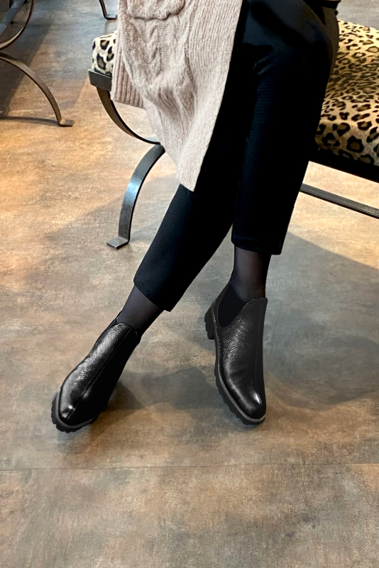 Satin black women's ankle boots, with elastics. Round toe. Low rubber soles. Worn view - Florence KOOIJMAN